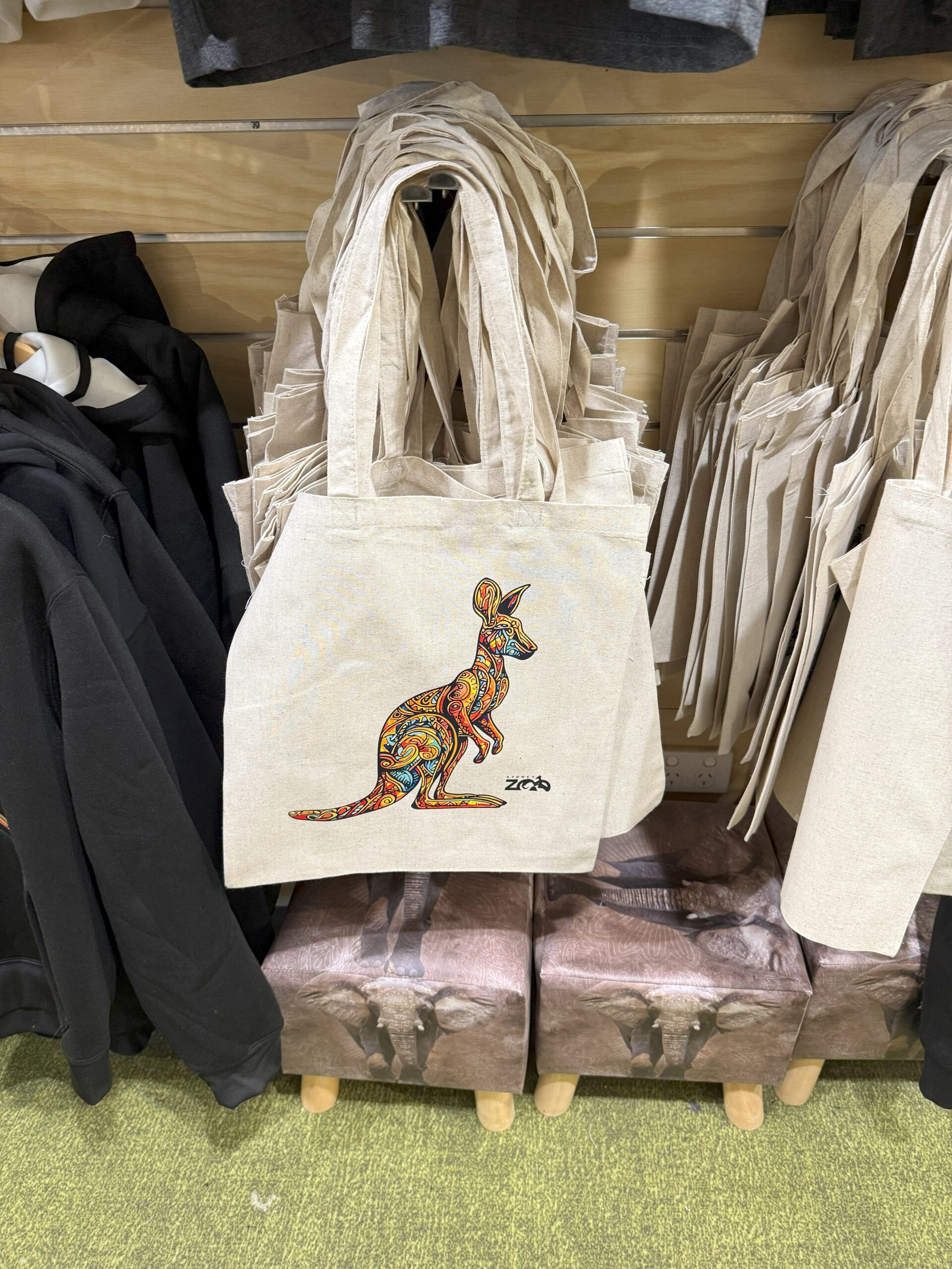 Beige tote bag with a colorful kangaroo design, perfect zoo merchandise for experience lovers.
