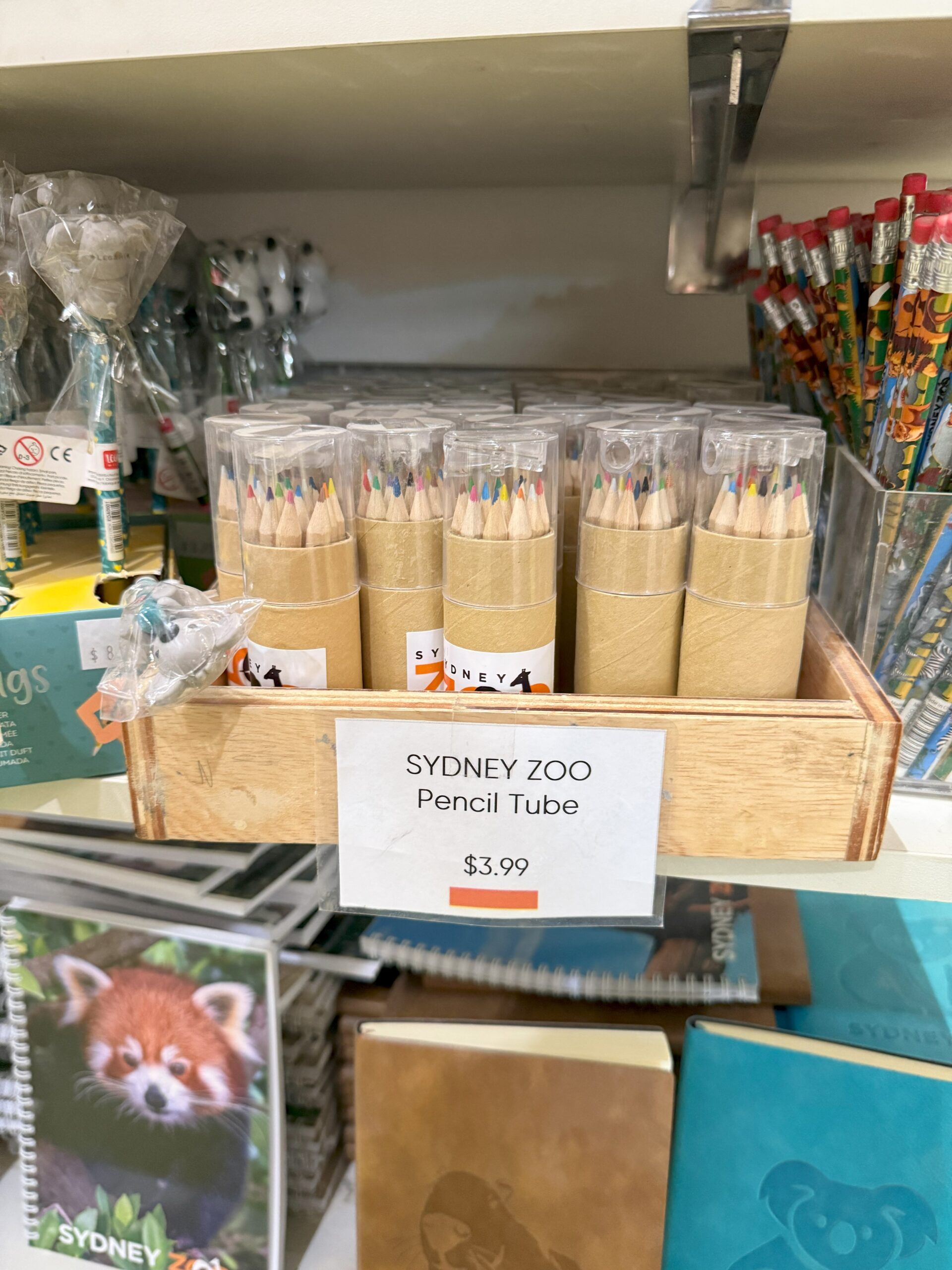 Sydney Zoo pencil tubes, perfect zoo merchandise for experience, displayed in a wooden tray at $3.99 each.