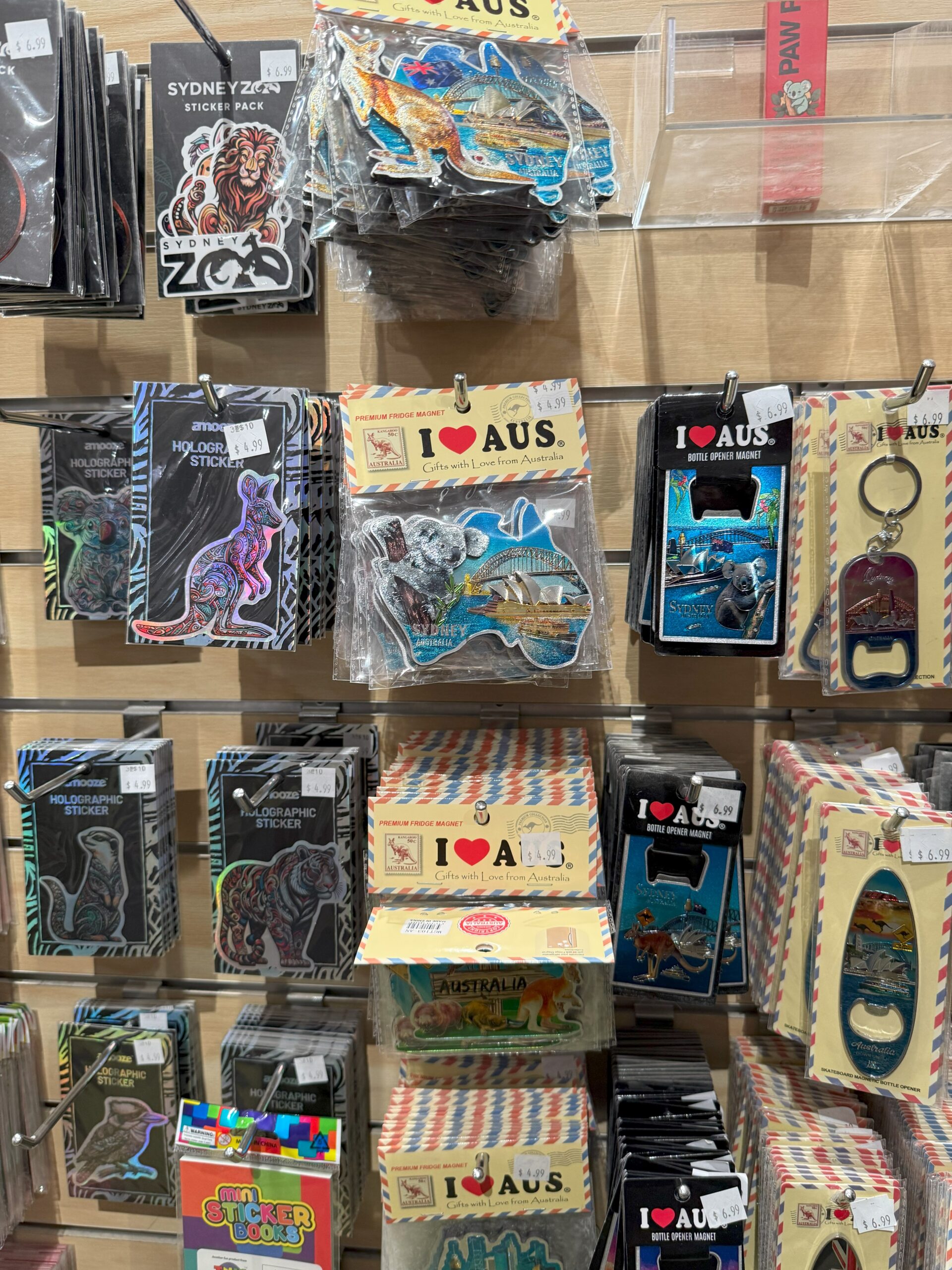Colorful Australia-themed souvenirs and zoo merchandise for experience on a store display wall.