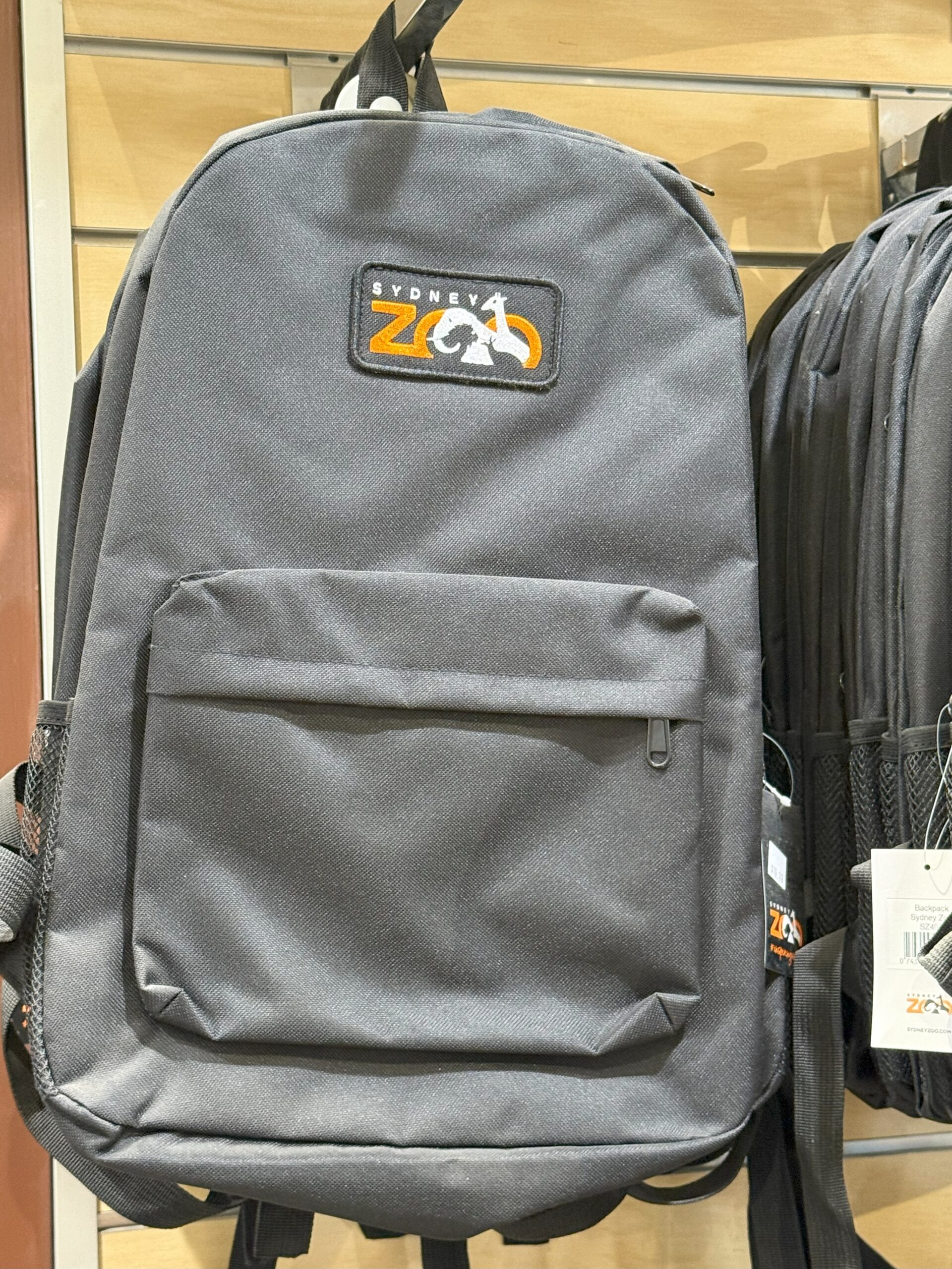 A gray backpack featuring a Sydney Zoo logo—perfect zoo merchandise for experience seekers.