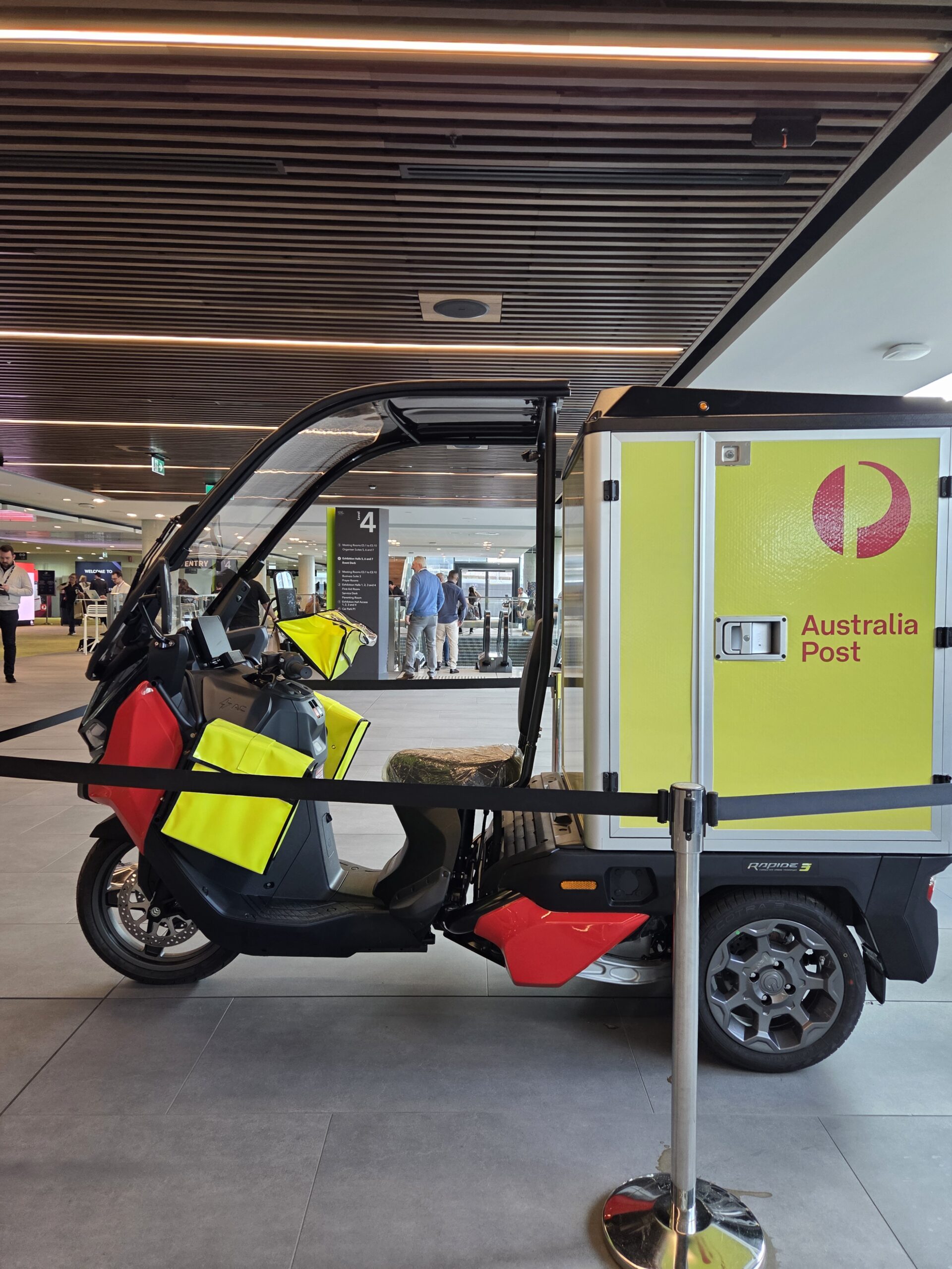 Three-wheeled Australia Post delivery vehicle at Sydney 2025 Online Retailer Conference.