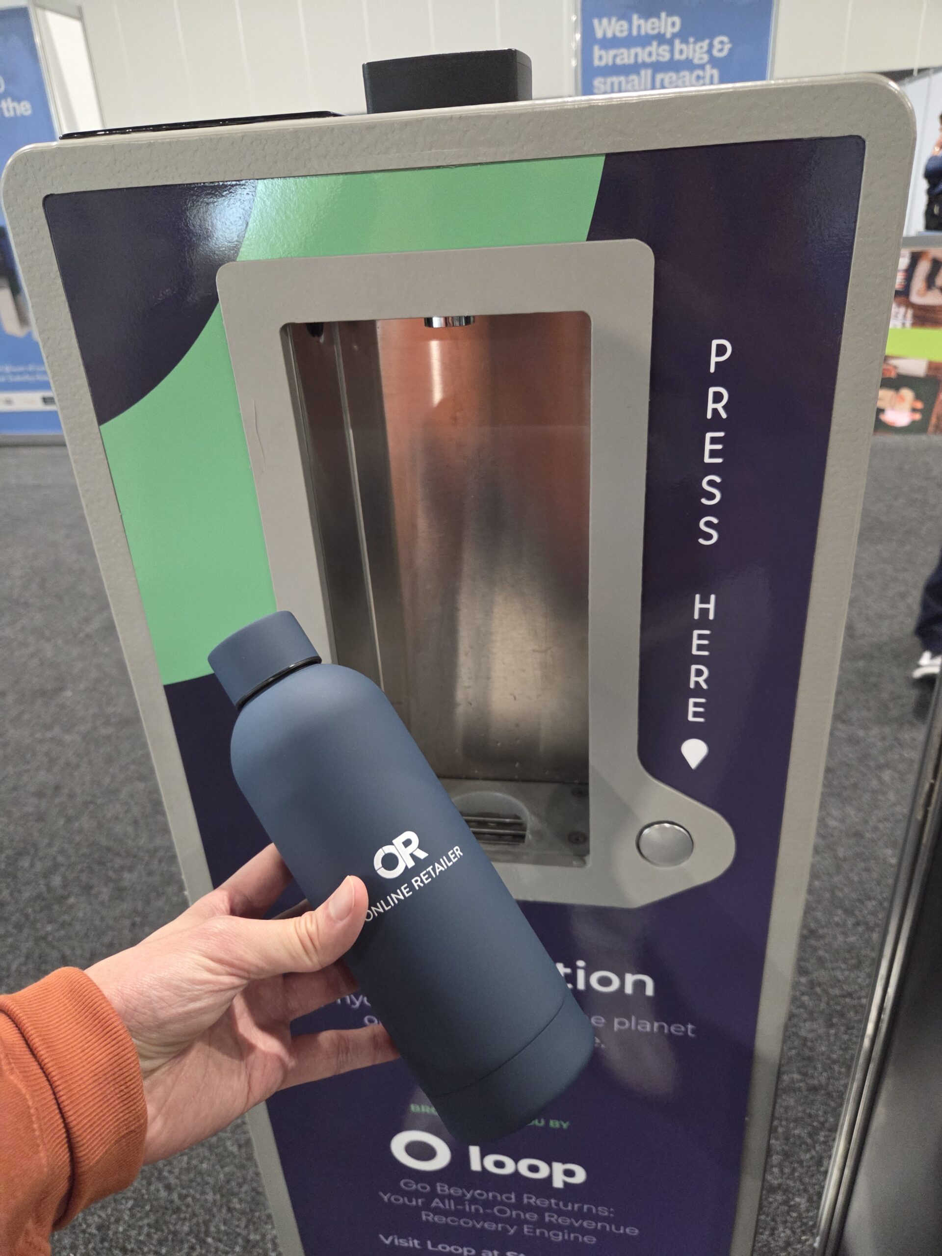 A person holds a reusable bottle by a water refill station at the Sydney 2025 Online Retailer Conference.