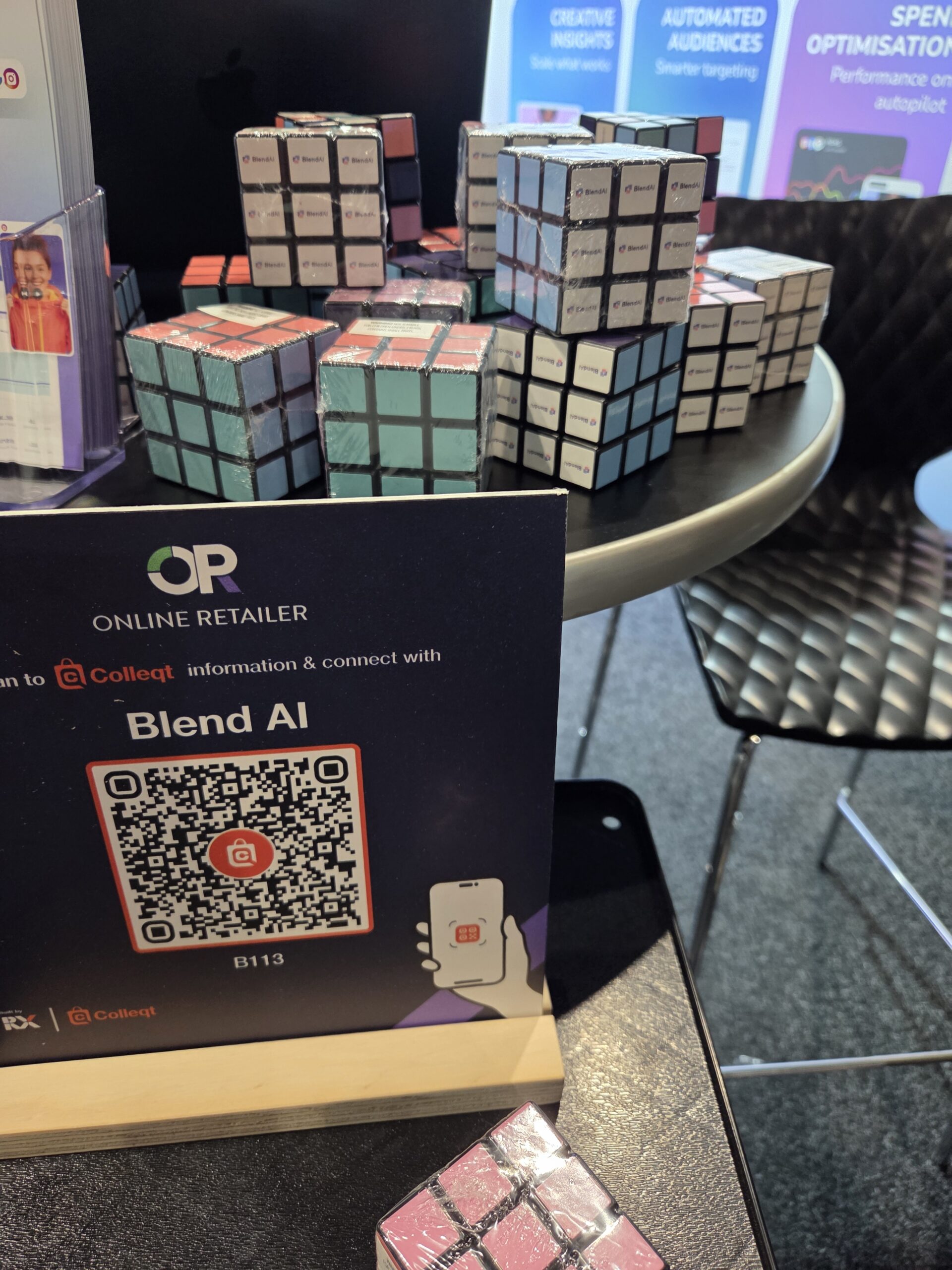 Rubik’s cubes stacked on a table with conference items and a QR code for Blend AI at the booth.