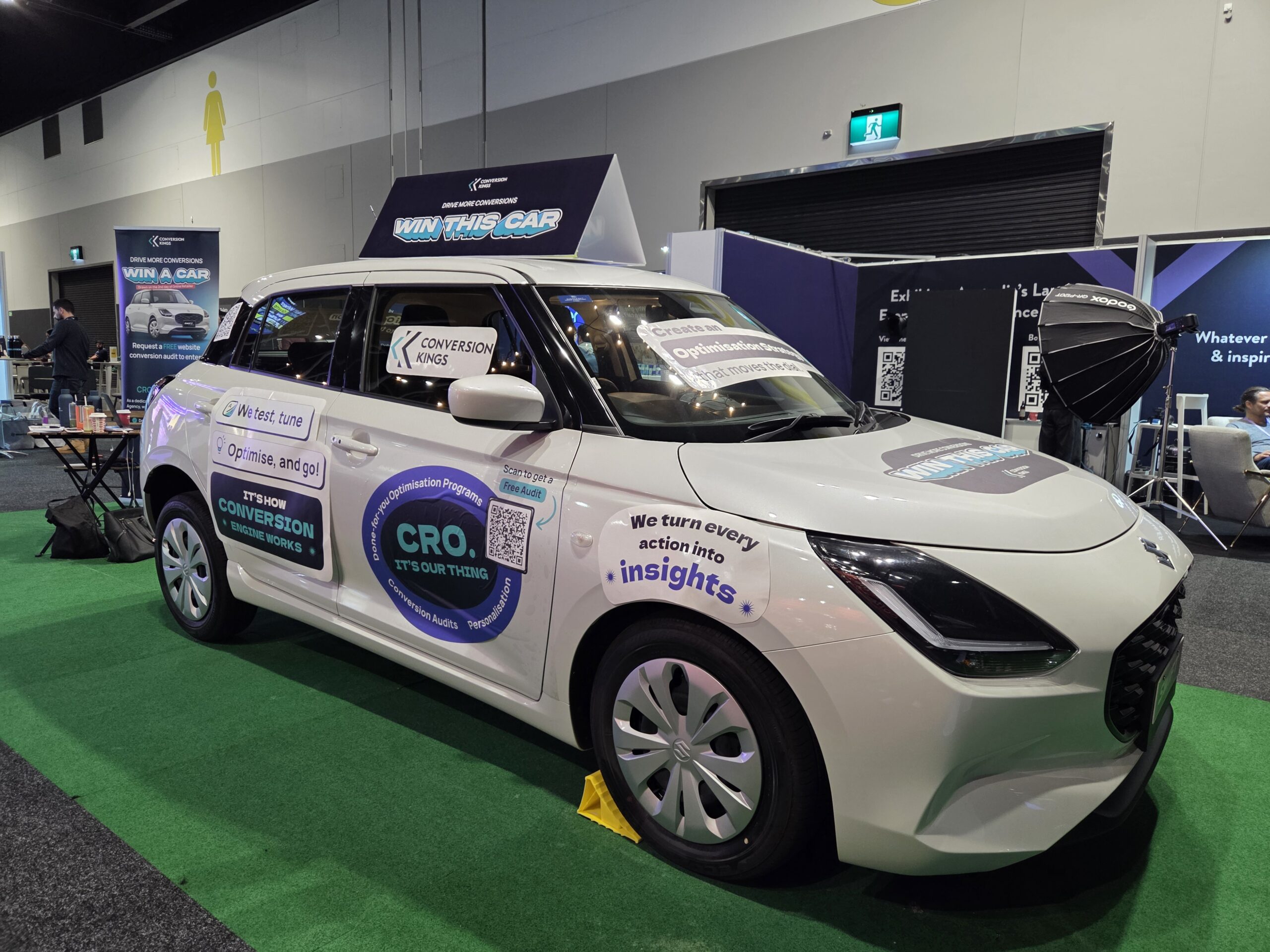 White car with promo decals at the 2025 Online Retailer Conference Sydney trade show booth.