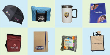 Eight branded promotional products Canberra, including umbrellas, bags, mugs, notebooks, and snacks.