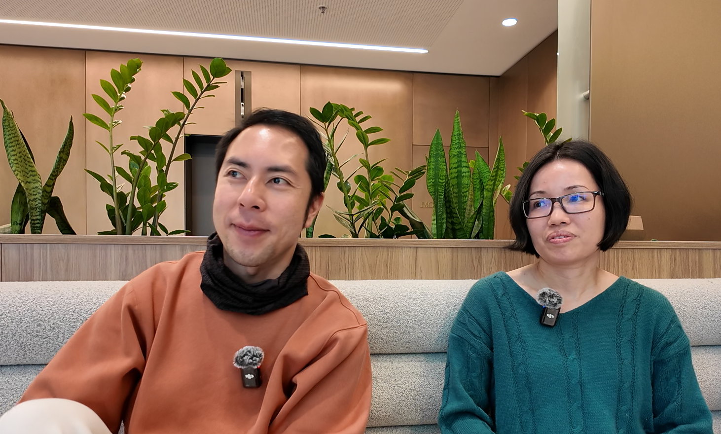 Two people discuss the merchandise and apparel business in Sydney, plants in the background.