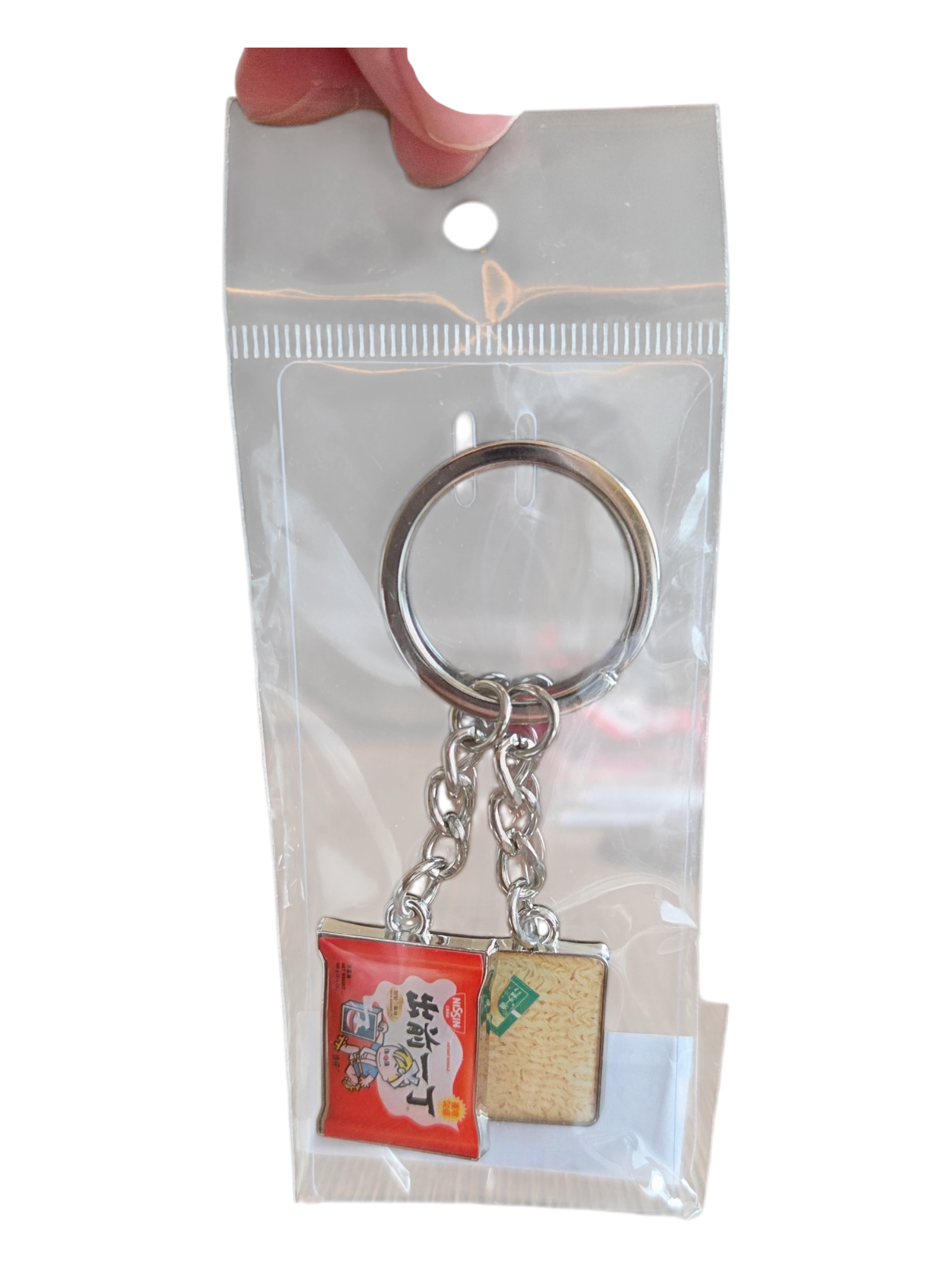 Custom merchandise keychain with instant ramen charms in clear packaging, held at the top.