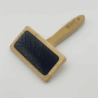Deshedding Brush for Cats & Puppies with rectangular wood handle and metal bristles.
