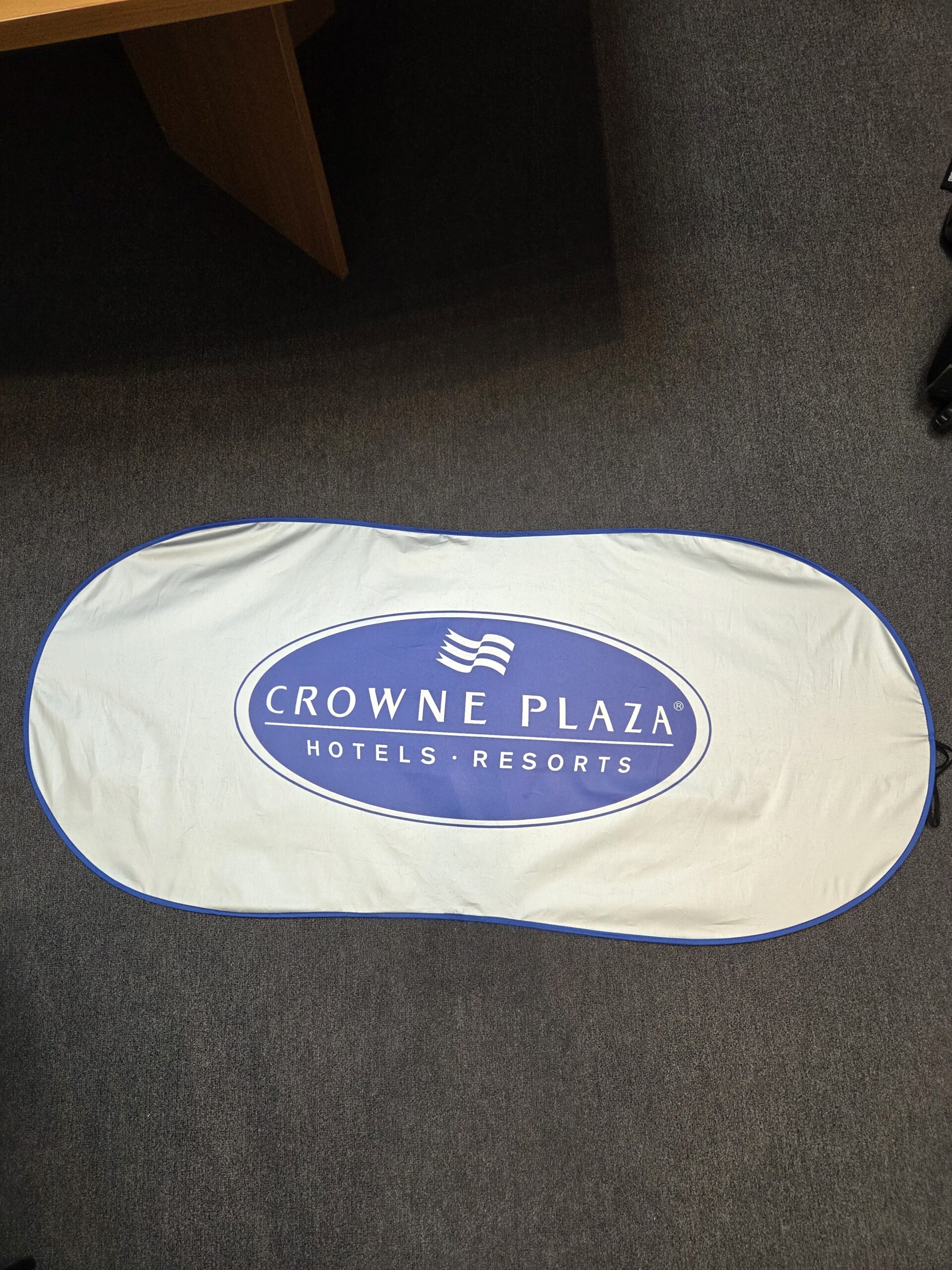 Foldable white sunshade with Crowne Plaza Hotels & Resorts logo—ideal for sun protection recommendations.