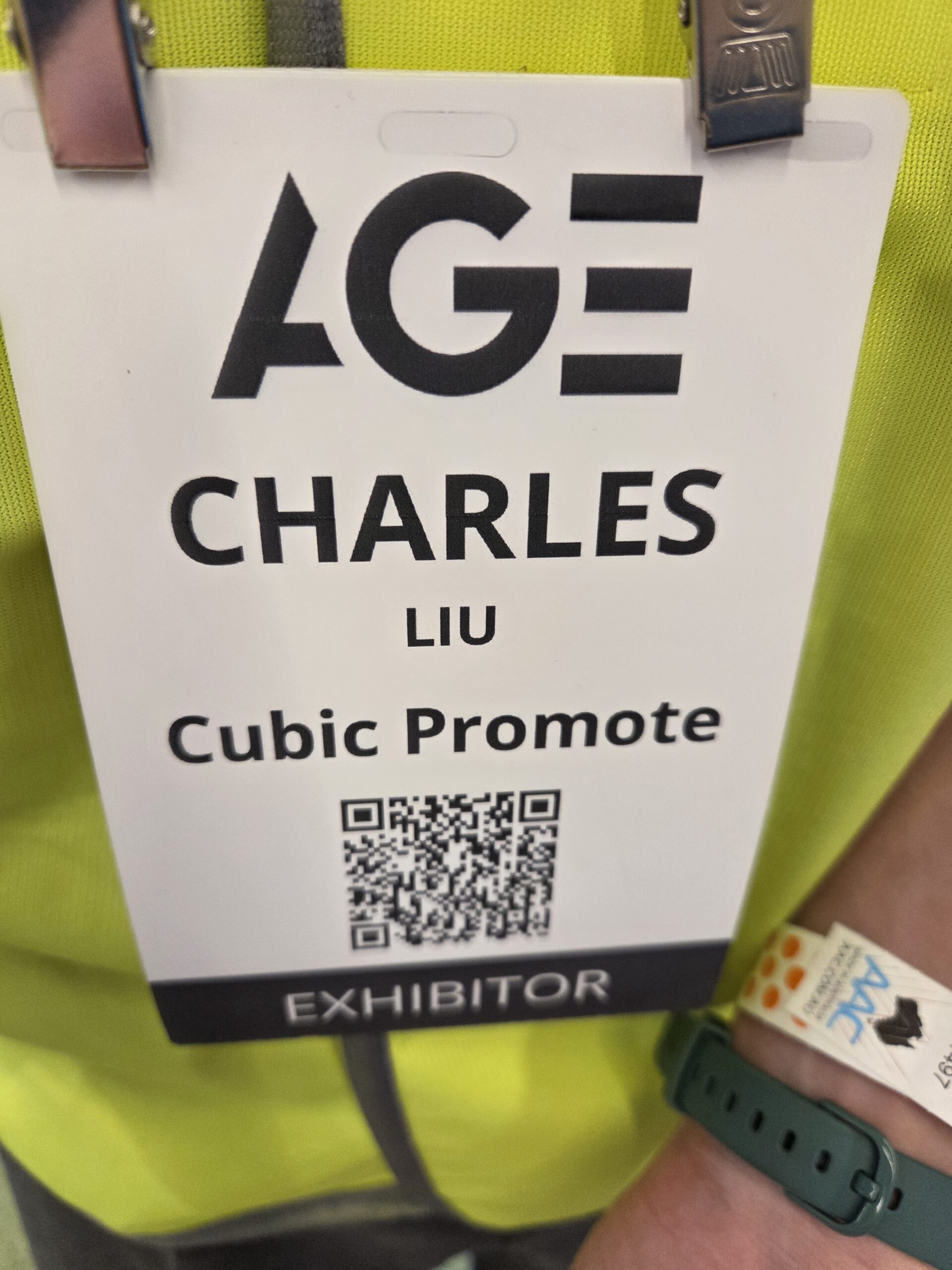Exhibitor badge for Charles Liu from Cubic Promote with a QR code at the Australasian Gaming Expo.