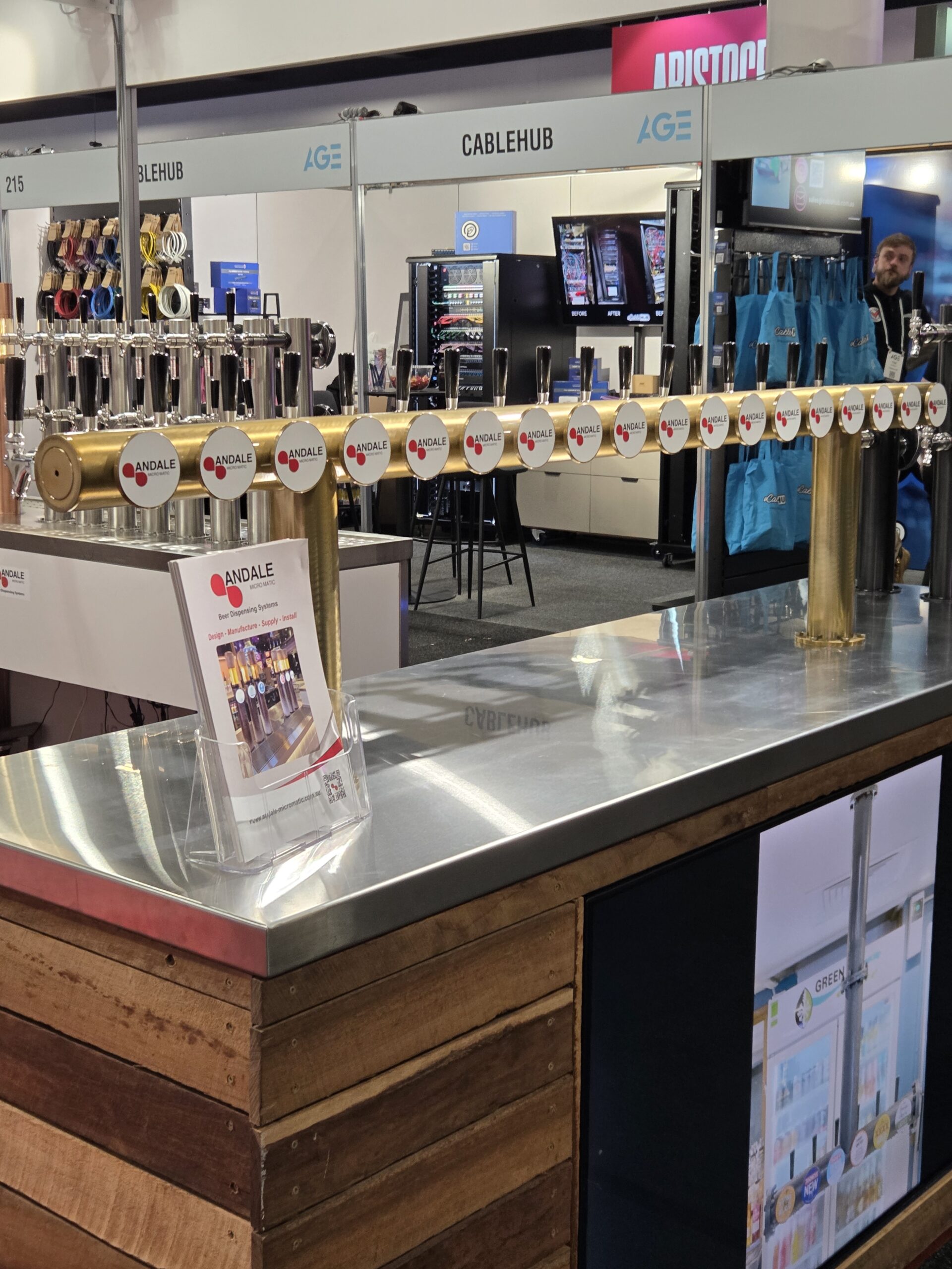 Beer taps lined up at the 2025 Australian Gaming Expo Day 1 booth with brochures nearby.