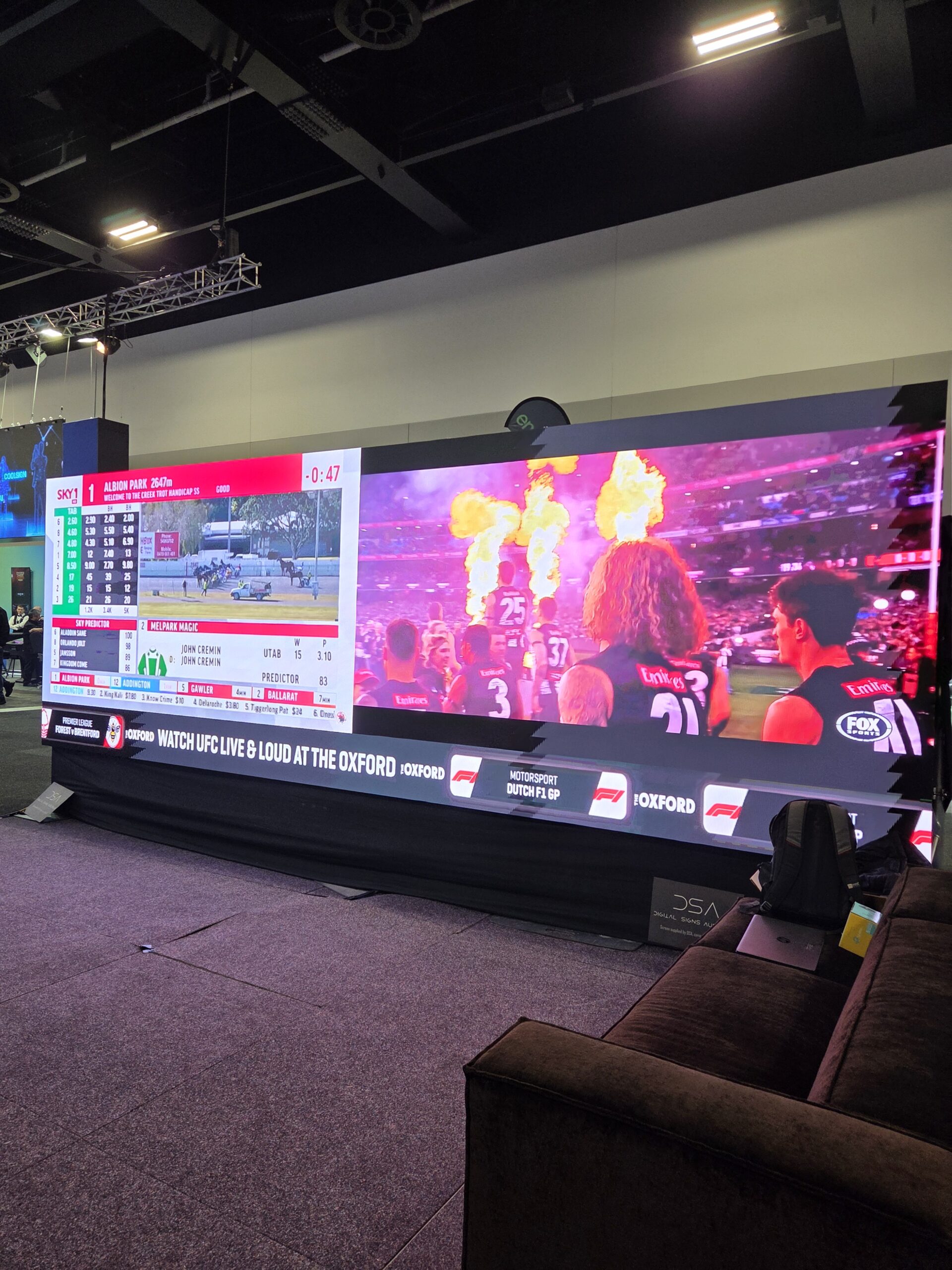 Large screen shows a sports match at the 2025 Australian Gaming Expo, Day 1 Wrap-Up.