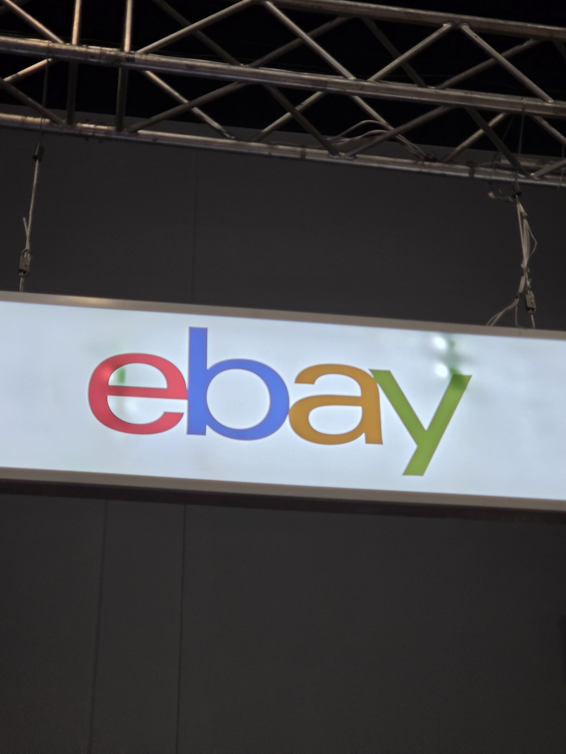 A white sign with the colorful eBay logo hangs from a metal frame at Collectfest Sydney 2025.