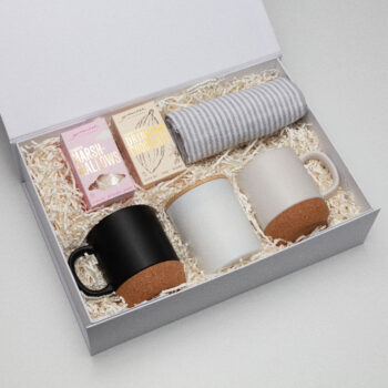 The First Impressions Hampers gift box with mugs, hot chocolate, marshmallows, and a towel.