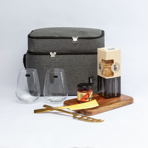 The Partnership Graze Packs: gray picnic bag, snacks, glasses, crackers, jam, cheese, knife & board.