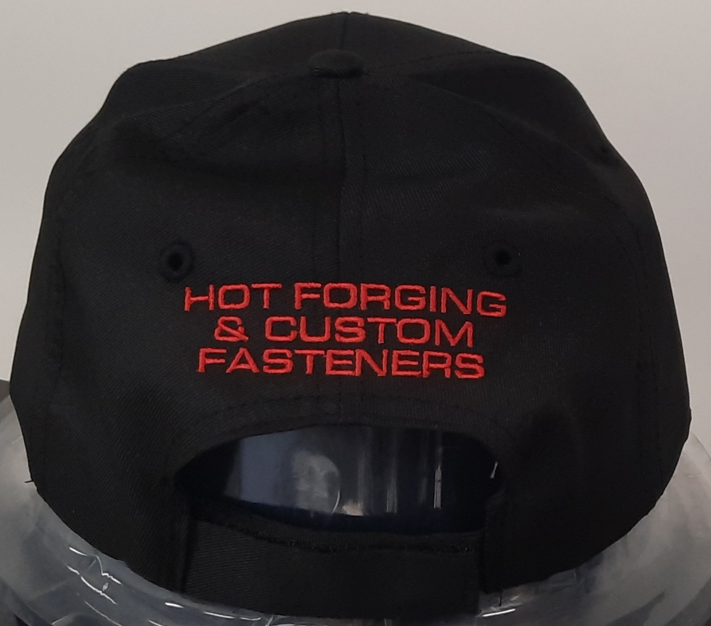 Black cap with red HOT FORGING & CUSTOM FASTENERS text on back, by EJ Hadaway.