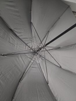 View from underneath open umbrellas, showcasing their metal ribs and gray fabric.