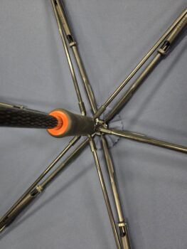 View from inside open umbrellas, showing metal spokes and central pole with orange ring.