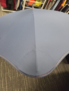 Blue umbrellas seen from above, with clothing racks visible in the background.