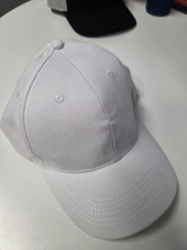 A classic white cap displayed on a clean, white surface.