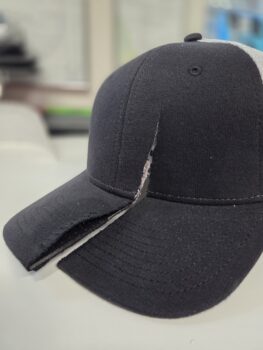 A sleek black cap featuring a bold diagonal cut across the front.