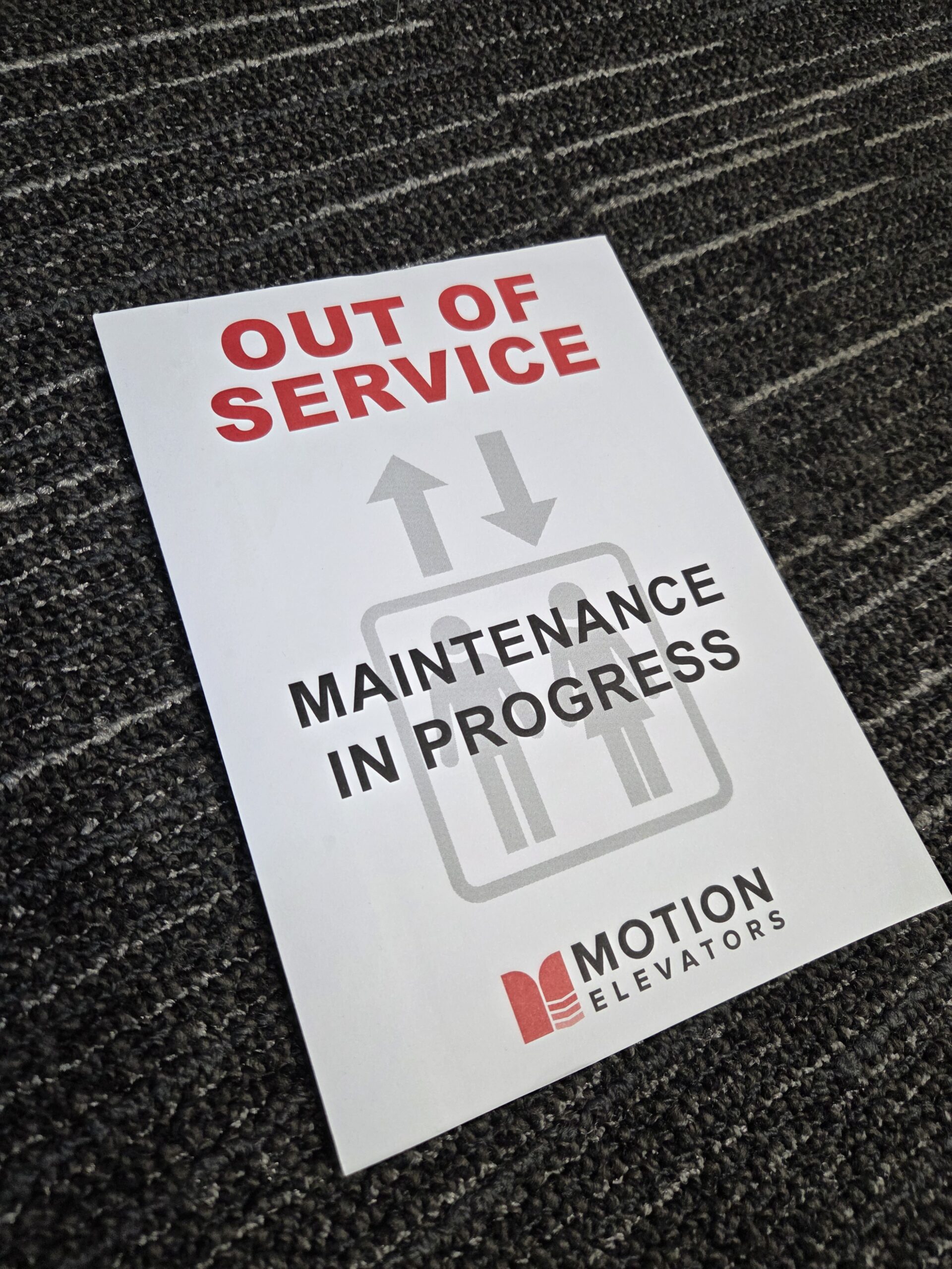 Sign on floor reads Out of Service, tear-away notepads, Maintenance in Progress, Motion Elevators.