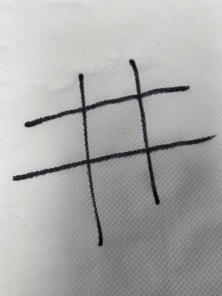 A hand-drawn tic-tac-toe grid, capturing authentic user generated content on white texture.