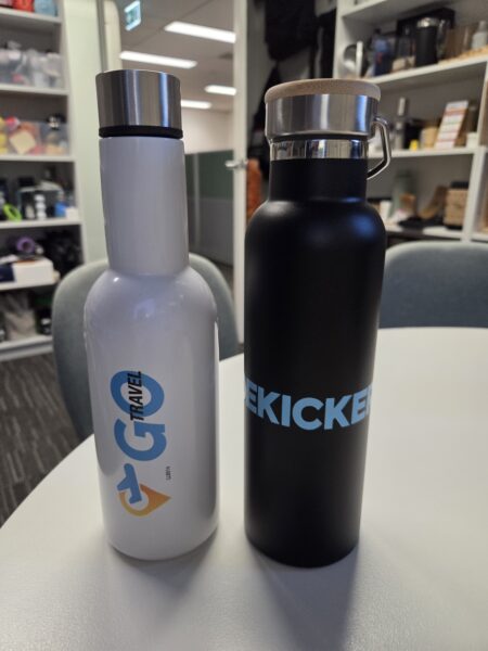 Two reusable water bottles on a table, captured as user generated content in an office setting.