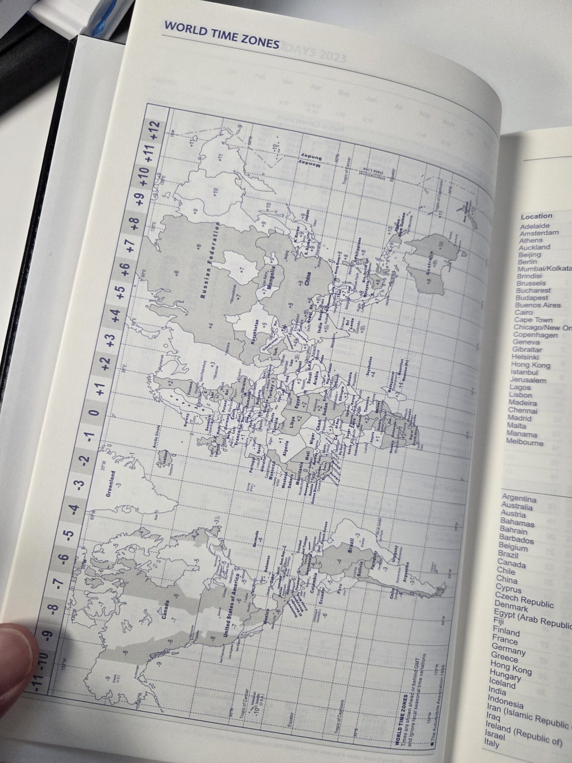 A world map showing global time zones, major cities, and a buying guide for diaries.