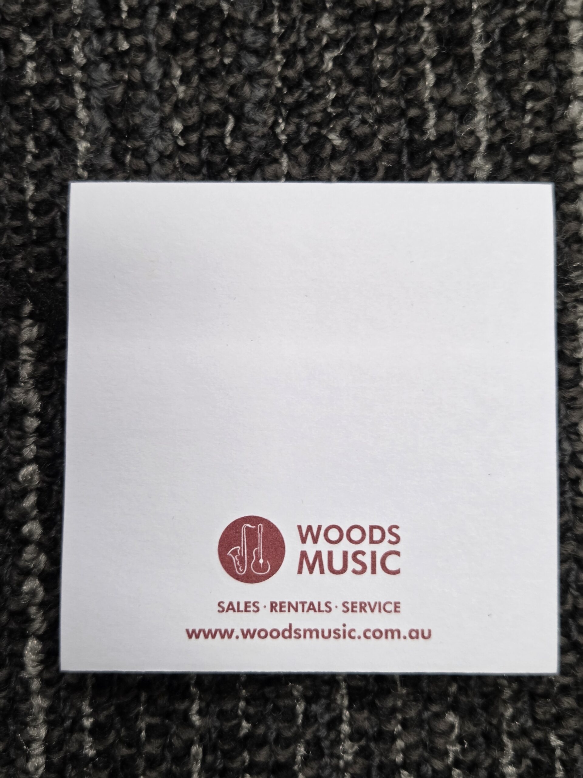 sticky note with woods music logo, text, and link printed at the bottom