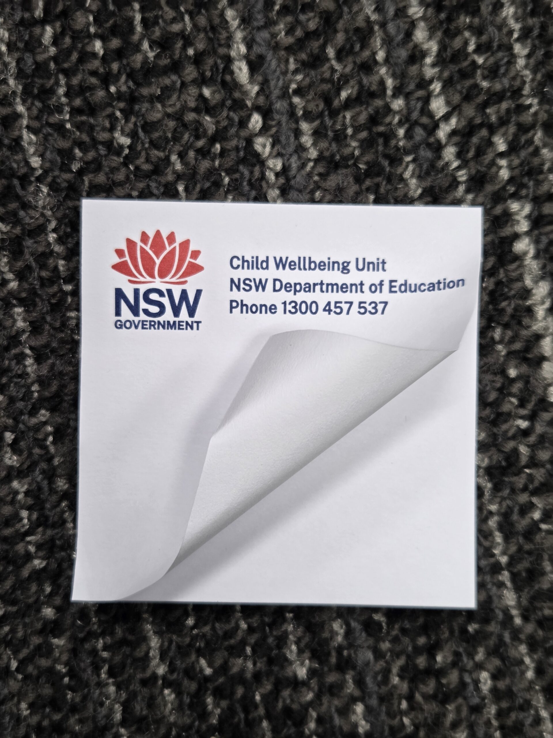 sticky notepad with NSW government logo and a fold