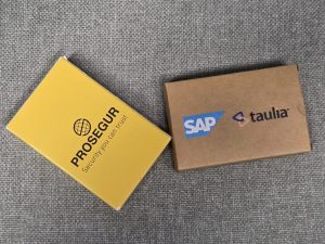 Two branded boxes: one yellow PROSEGUR, one brown (SAP, taulia) for promotional games.