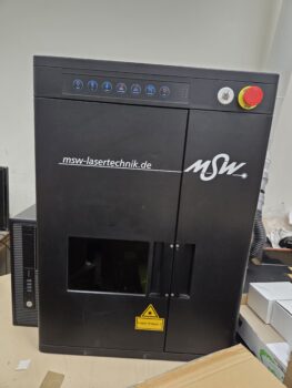 Black MSW laser machine with control buttons, safety label, and note on Print Setup Fees.