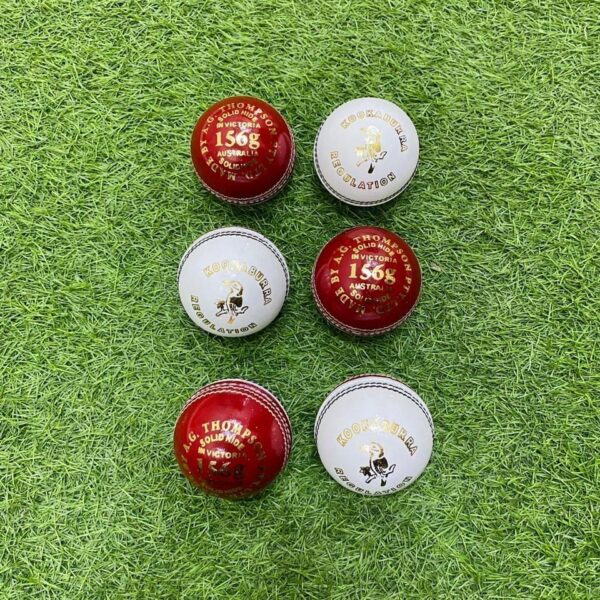 Five Layers Cricket Balls, essential gear, arranged on green artificial grass.