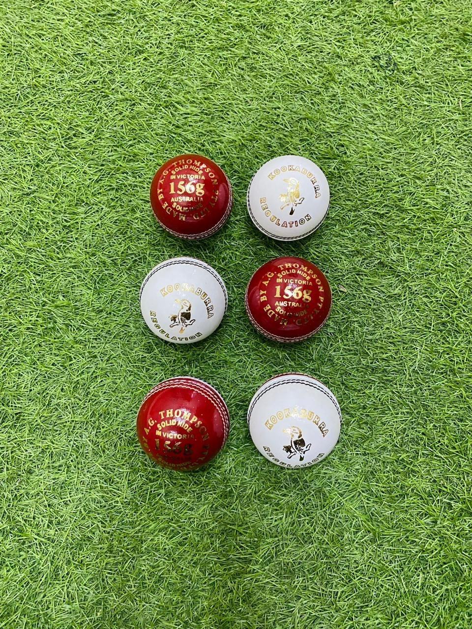 Five Layers Cricket Balls, essential gear, arranged on green artificial grass.