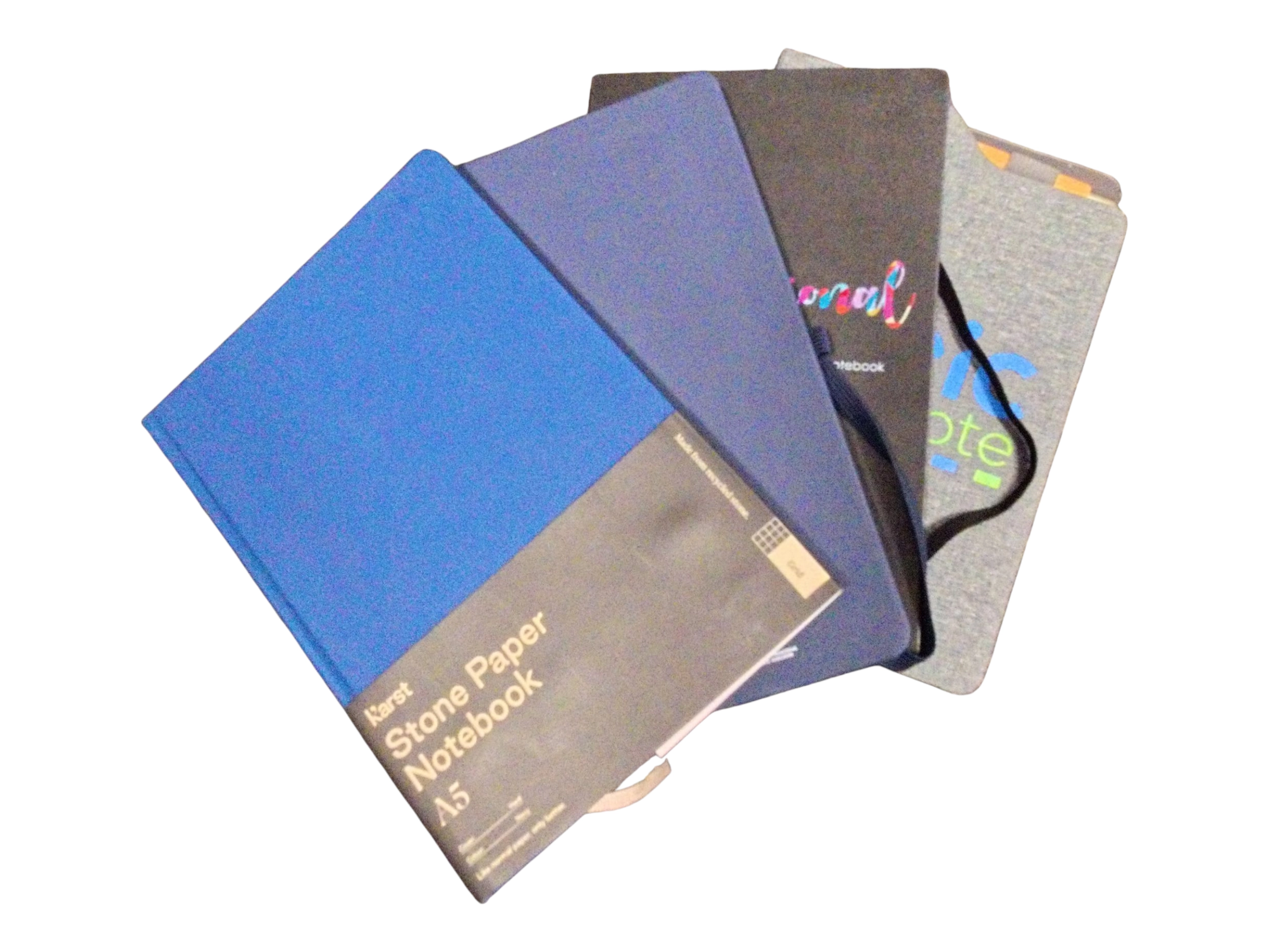 Four notebooks with vibrant covers are fanned out on a white background.