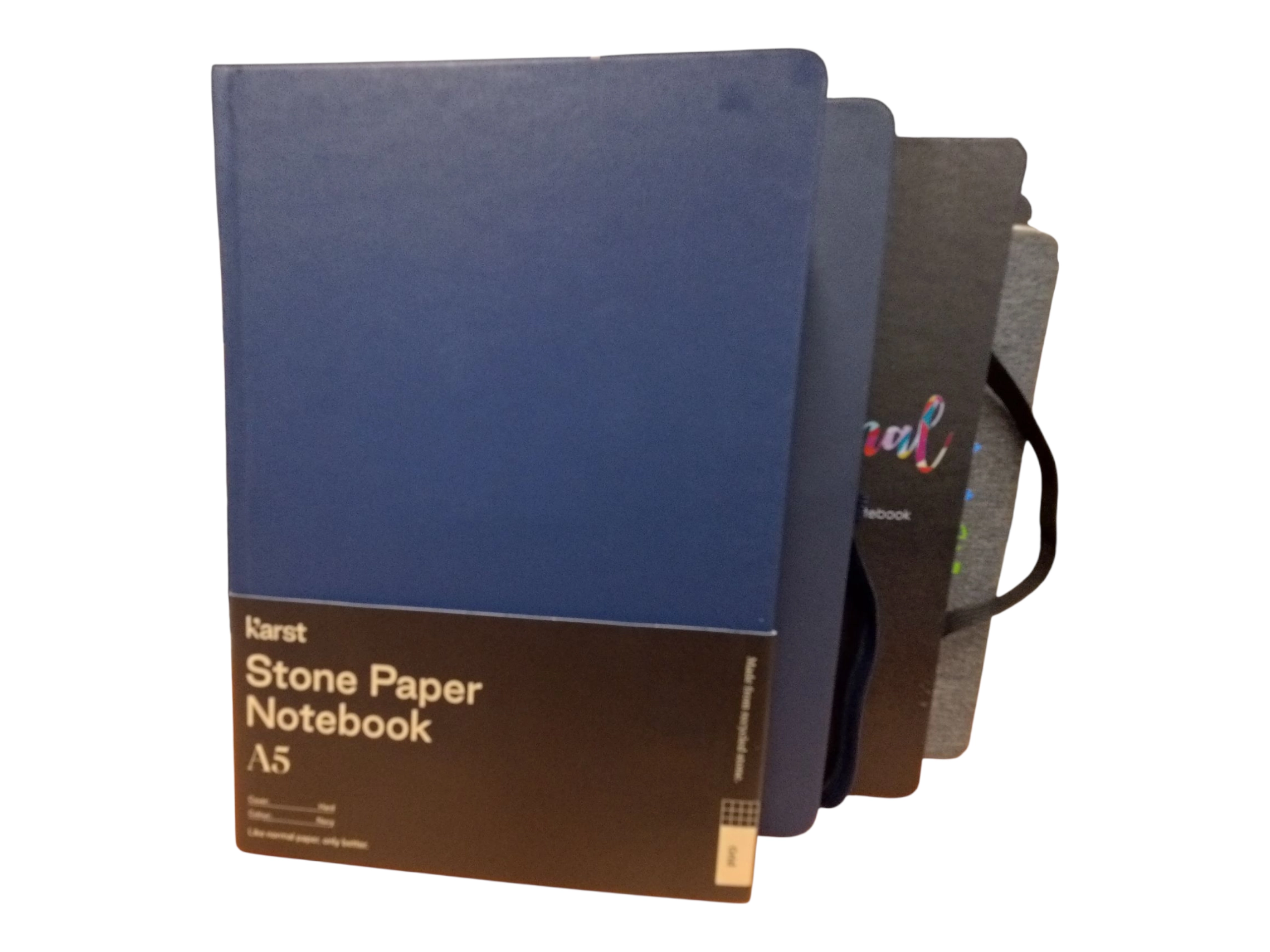Four A5 notebooks made of stone paper, with a blue cover in front, standing upright.