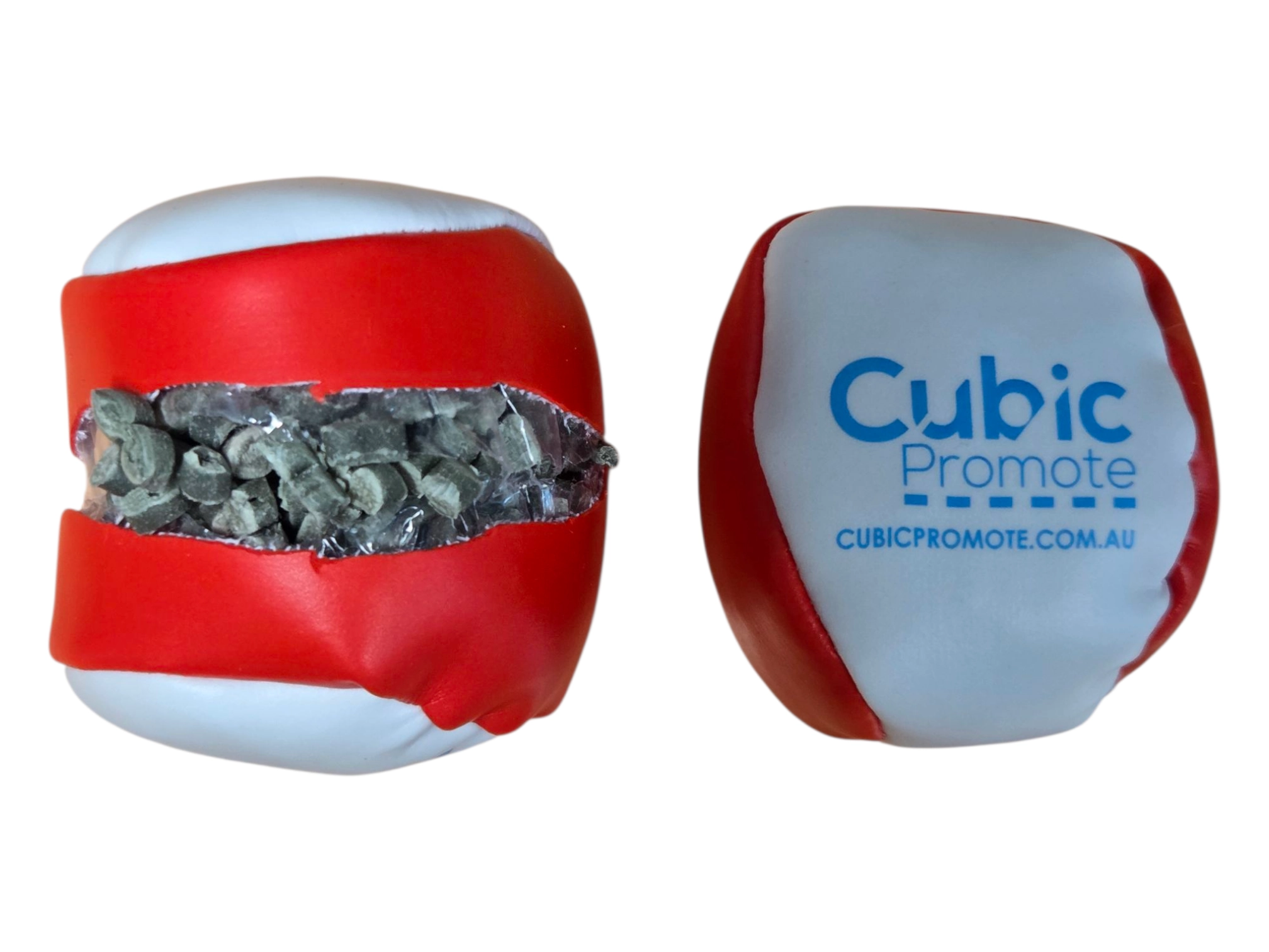 Two red and white hackysacks, one cut open to reveal small rocks inside.