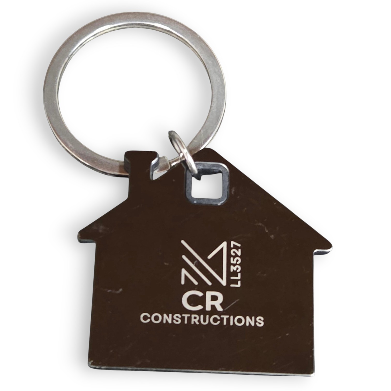 House-shaped metal keychain—engraved logo, highlighting quality over plastic keyrings.