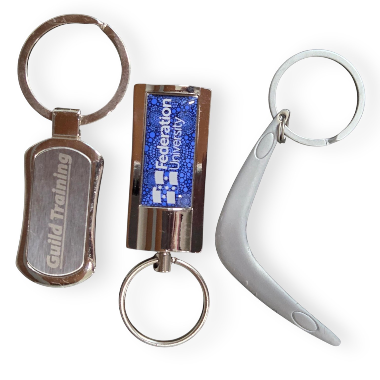 Three metal keychains highlight the quality of metal vs plastic keyrings in style and design.
