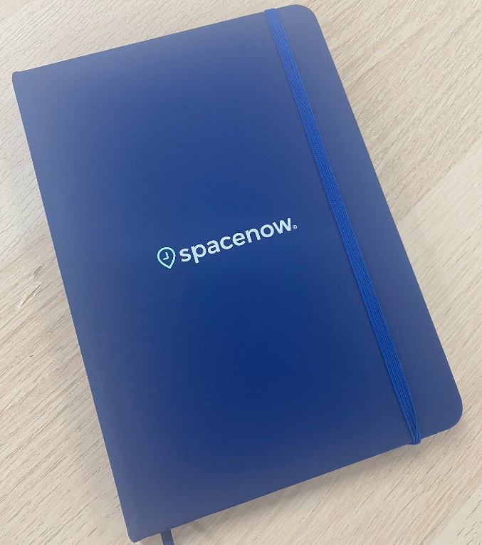 Blue notebook with Spacenow. logo, perfect for your next work or project notes.