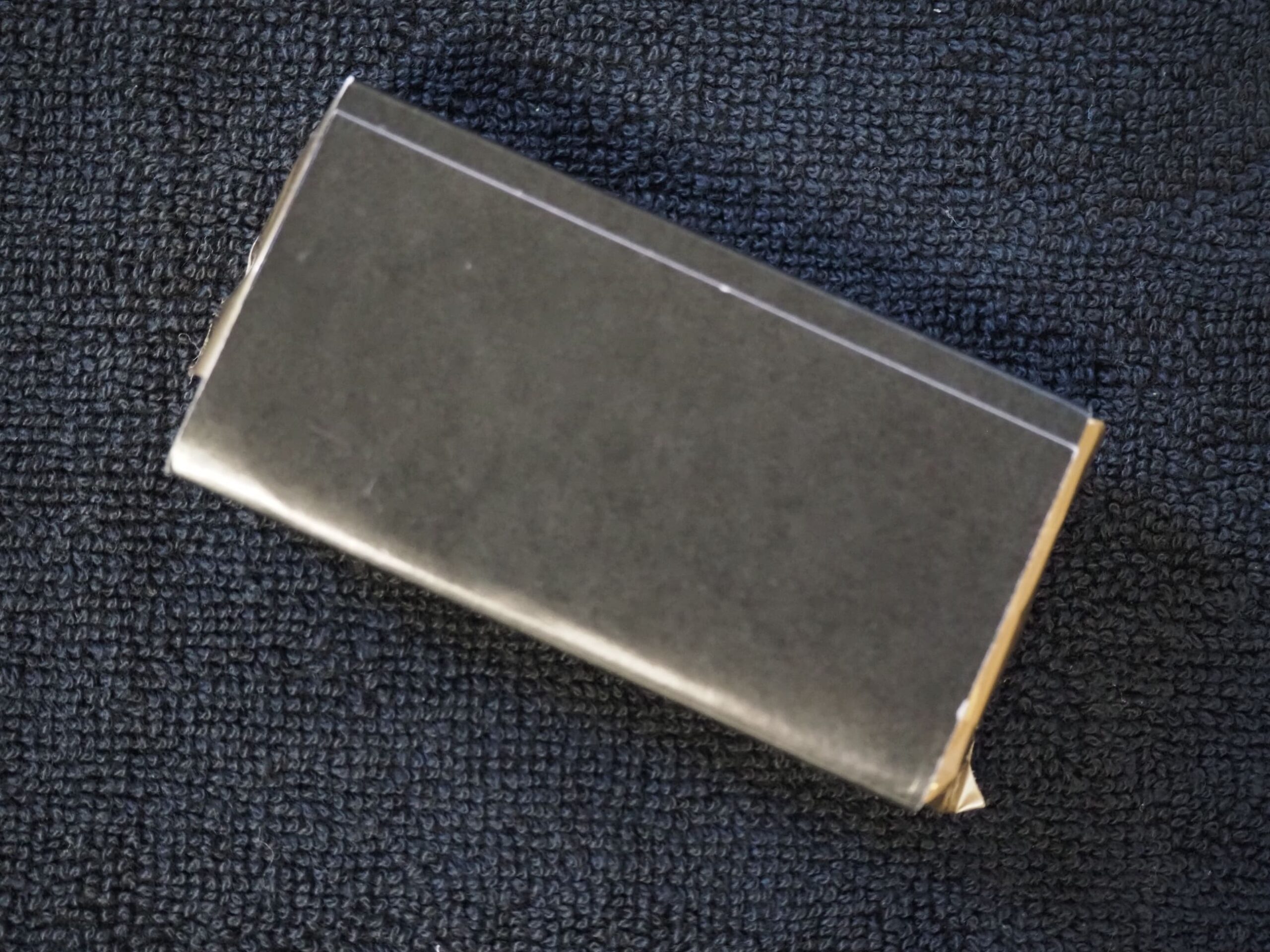 A black rectangular box on a dark textured fabric, inspired by a Mission Australia Client Story.