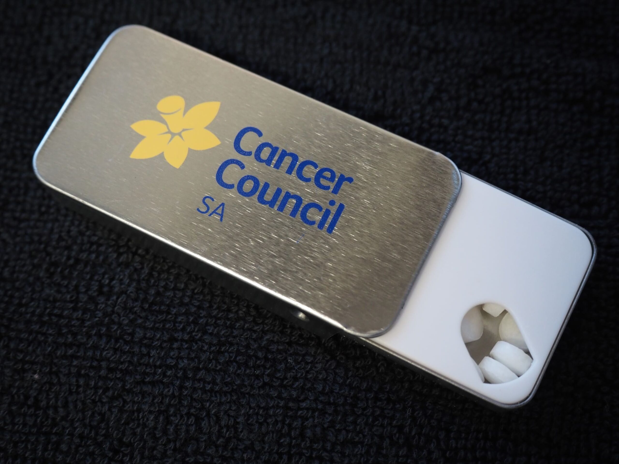 A Cancer Council SA mint tin with white mints, supporting cancer support in South Australia.