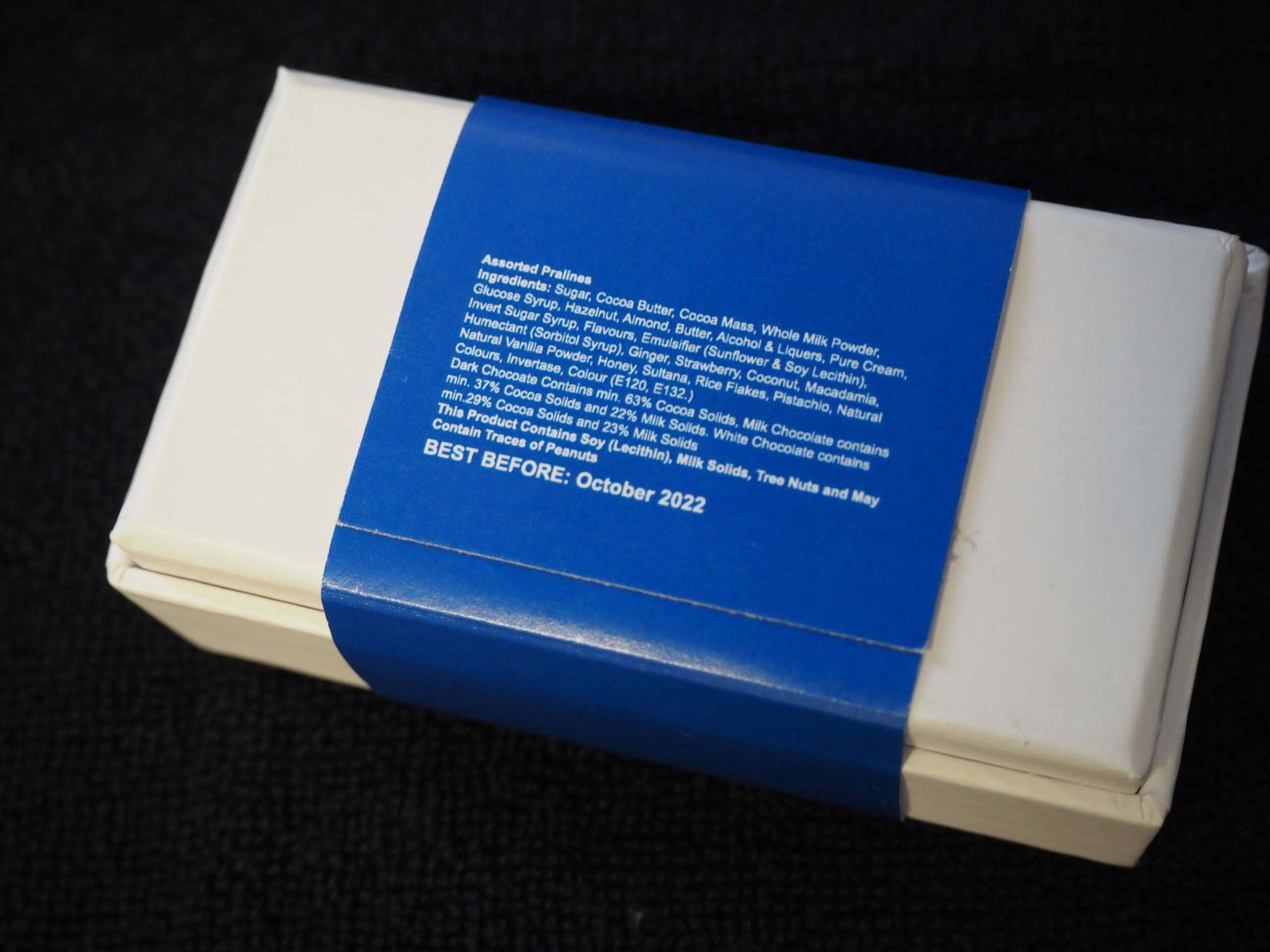 A white box with a blue label featuring Magellan Logistics in this client story, BEST BEFORE: Oct 2022.