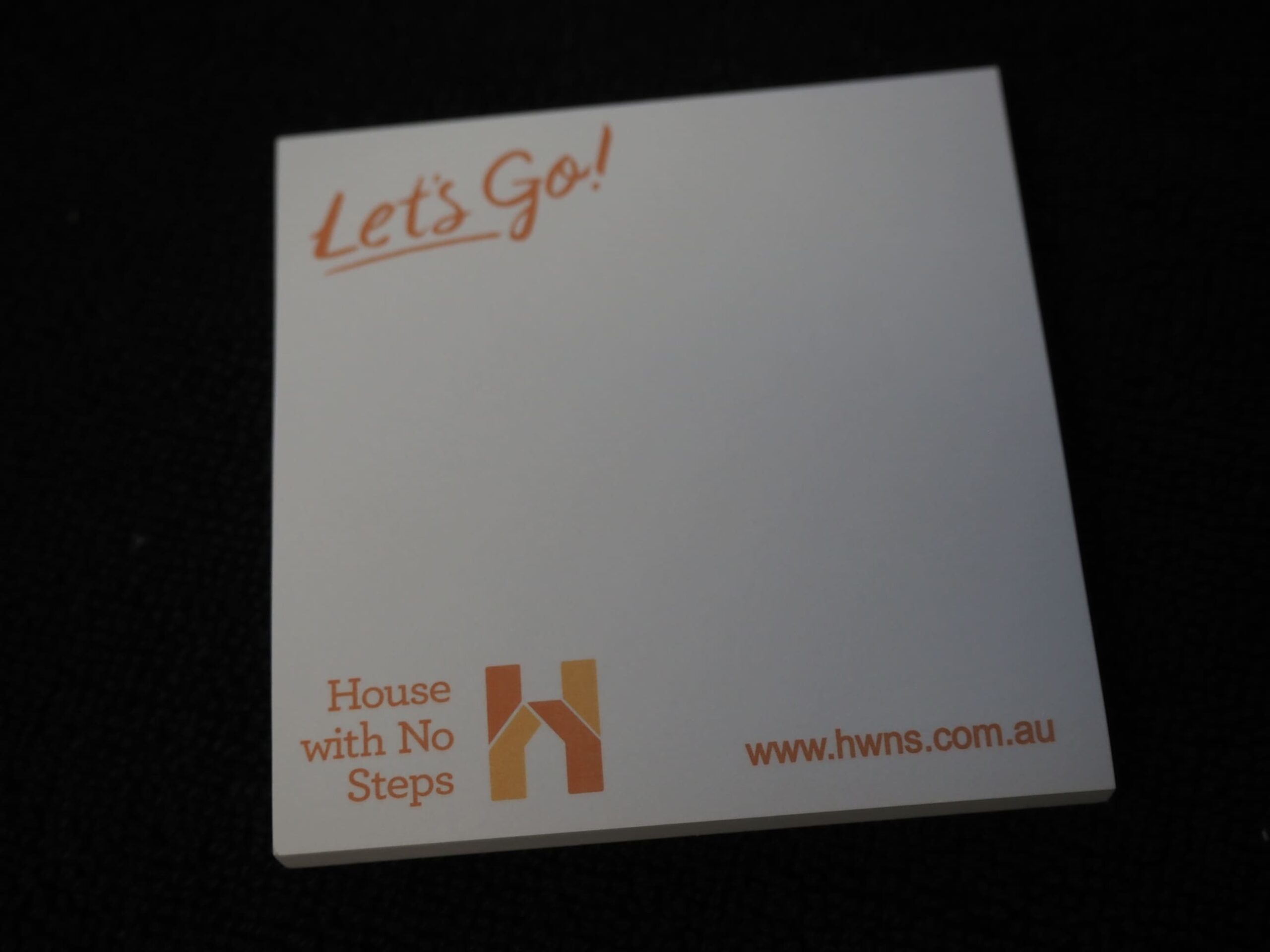 A notepad with Lets Go! and House With No Steps logo, plus their website at the bottom.