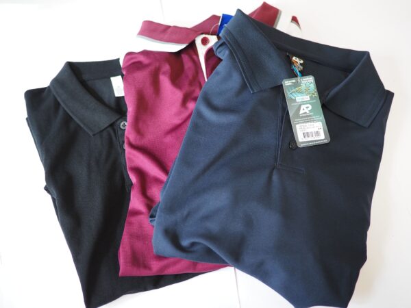 Three folded polo shirts in black, maroon, and navy blue polo, each with tags attached.