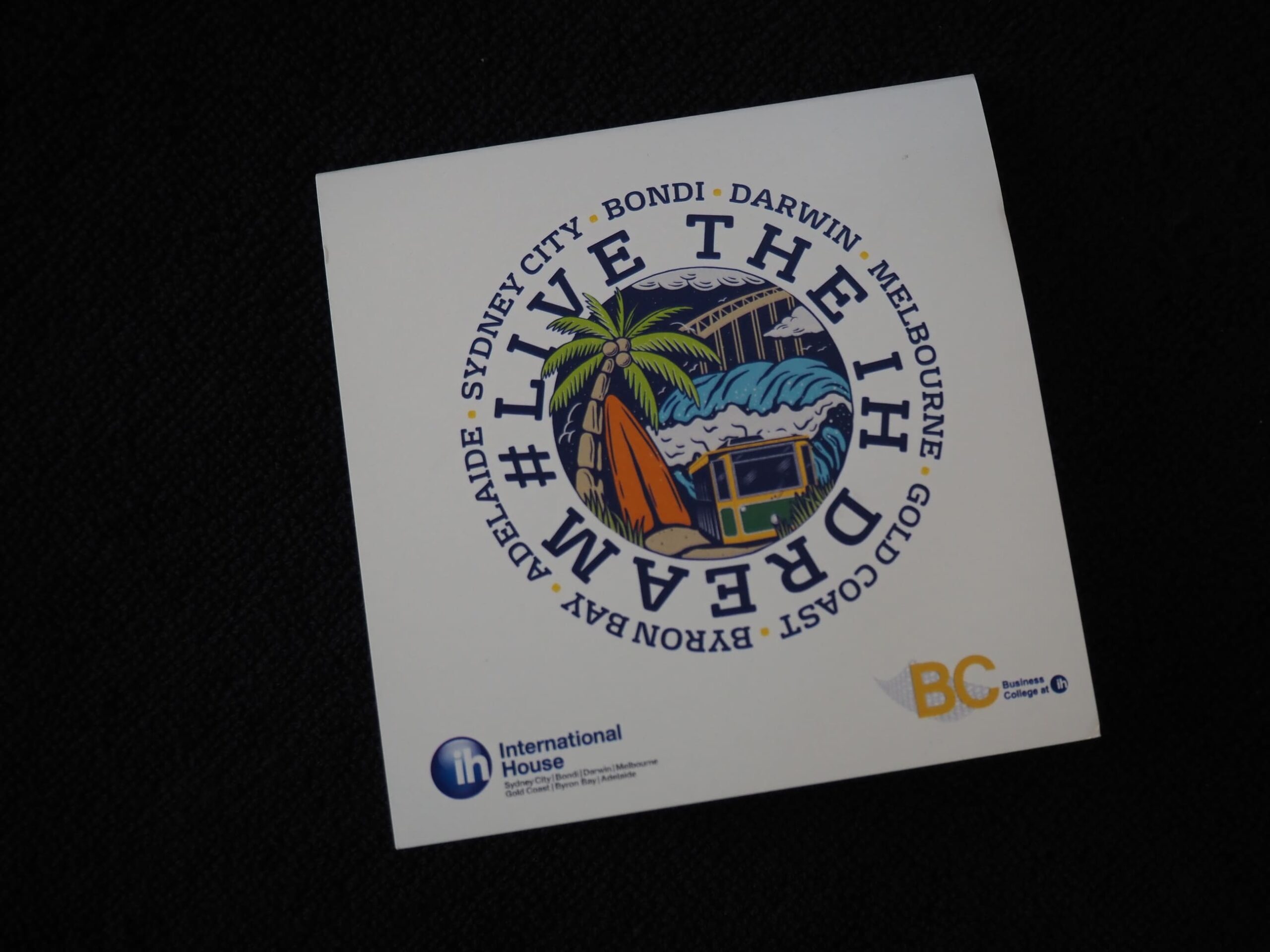 A sticker with #LiveTheDream, Australian cities, and a van by International House beach.