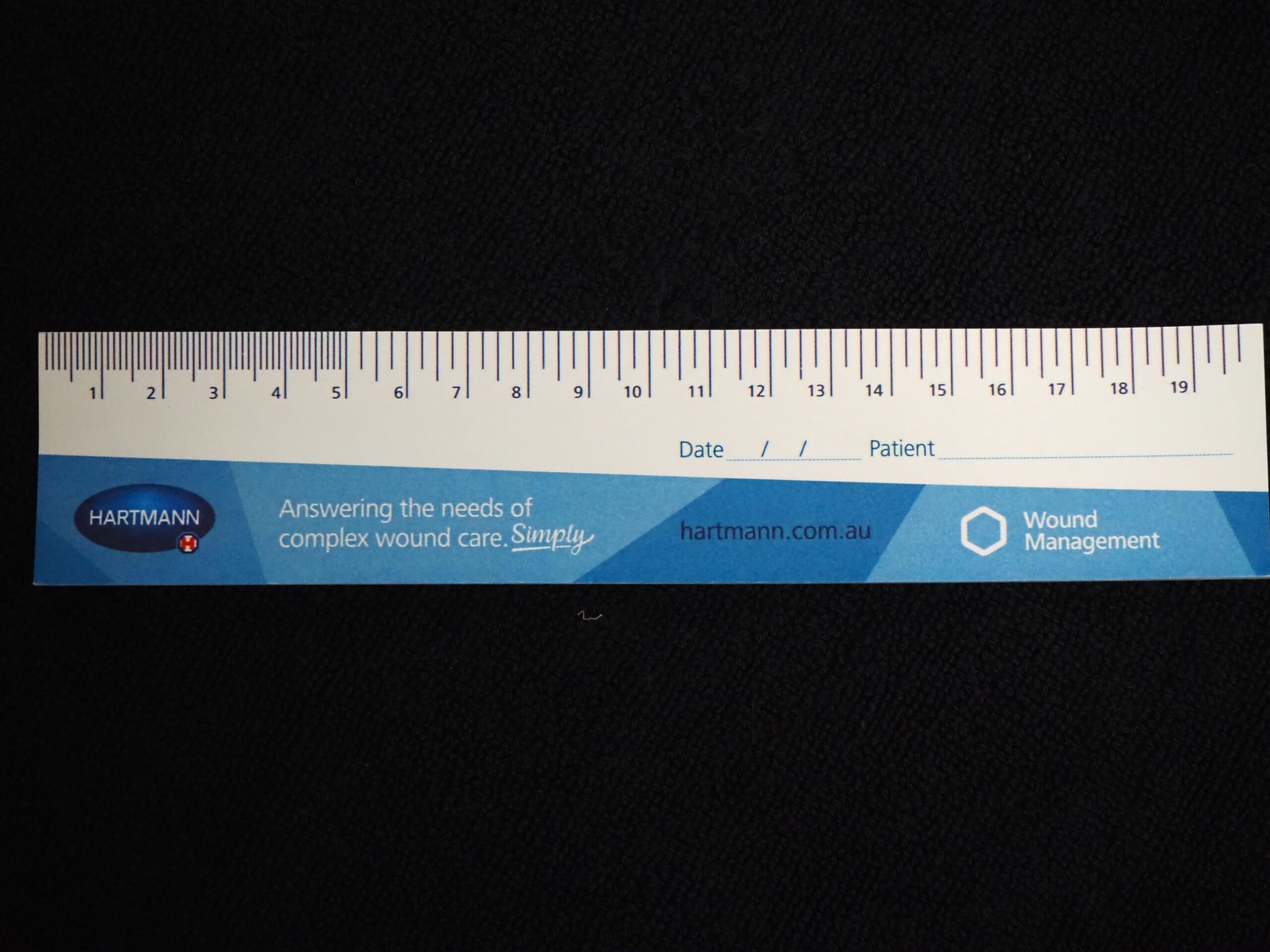 A blue wound measurement ruler with centimeter markings and HARTMANN Australia branding.