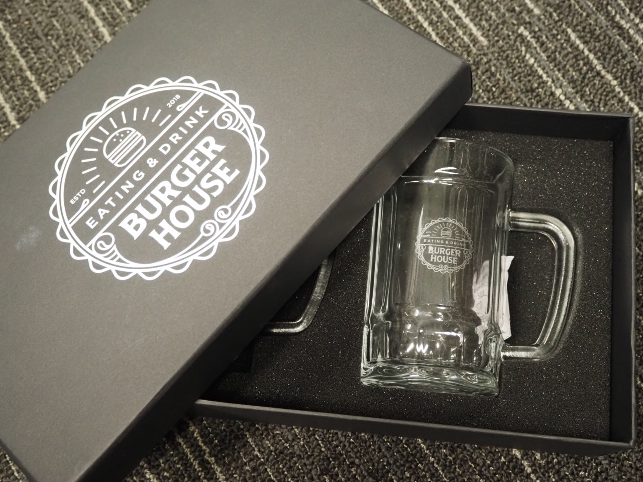 A glass mug in a foam-lined box, both labeled Burger House.