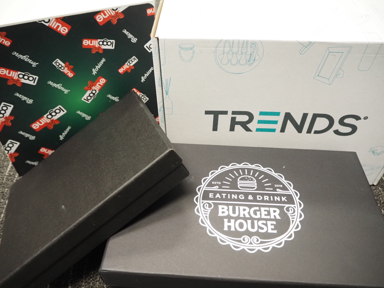 Stacked branded boxes, featuring Burger House, arranged neatly on a gray surface.